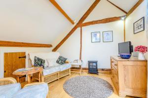 ein Wohnzimmer mit einem Sofa und einem TV in der Unterkunft The Bothy in Ross on Wye