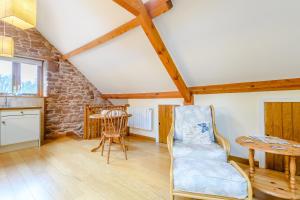 a living room with a table and a chair at The Bothy in Ross on Wye