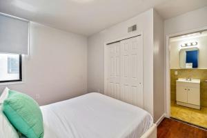 Dormitorio pequeño con cama blanca y espejo en Stylish & Great location next to the convention center, en Filadelfia