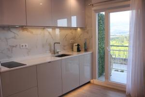 uma cozinha com balcões brancos e uma grande janela em Apartamentos La Herradura Viñas em Haro