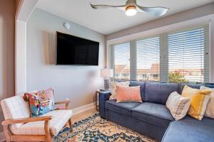 a living room with a blue couch and a chair at Boho Bayshore 42 in Ocean City