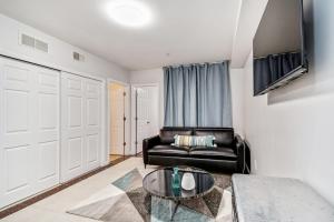 a living room with a leather couch and a glass table at New and Cozy 1BD Apt in the heart of Philly! in Philadelphia