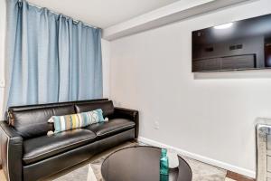 a living room with a leather couch and a tv at New and Cozy 1BD Apt in the heart of Philly! in Philadelphia