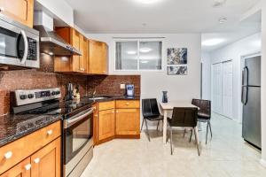 a kitchen with wooden cabinets and a table with chairs at Spacious&stylish 2bd apt with great location! in Philadelphia
