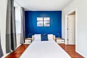sypialnia z niebieską ścianą i dużym łóżkiem w obiekcie Amazing 2BD steps from the Convention Center w Filadelfii