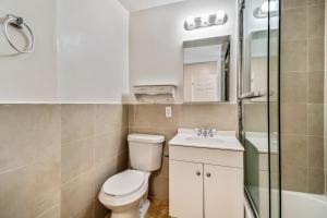 ein Badezimmer mit einem WC, einem Waschbecken und einem Spiegel in der Unterkunft Amazing 2BD steps from the Convention Center in Philadelphia
