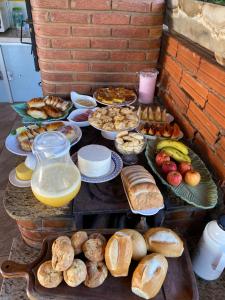 a table full of different types of bread and pastries at Pousada Chalés Praia Vermelha in São João Batista do Glória