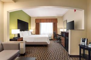 エドモンドにあるHoliday Inn Express Hotel & Suites Edmond by IHGのベッドとテレビがあるホテルの部屋