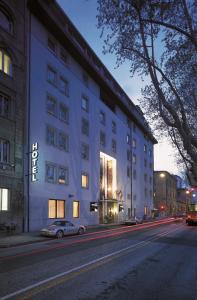 un edificio blanco con un coche aparcado delante de él en Hotel Buonconsiglio, en Trento