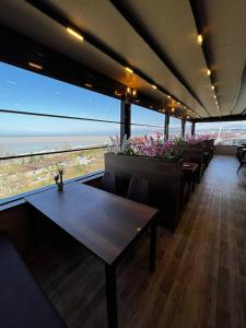 a restaurant with tables and a view of the ocean at Avni Bey Otel in Araklı