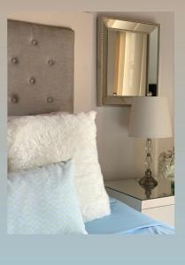 a bedroom with a bed with a mirror and a lamp at Casa hermosa amoblada norte de Valledupar in Valledupar