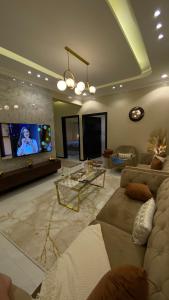 a living room with a couch and a flat screen tv at ABHA GOLDEN in Abha