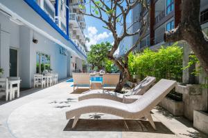 a patio with two lounge chairs and a tree at Kokotel Pattaya South Beach in Pattaya +32 photos