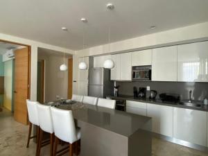 une cuisine avec une table et quelques placards blancs dans l'établissement Departamento 2 recámaras Anah, à Playa del Carmen