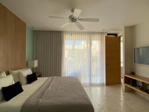 une chambre avec un lit et un ventilateur de plafond dans l'établissement Departamento 2 recámaras Anah, à Playa del Carmen 53 autres photos