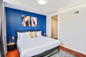 a bed in a room with a blue wall at Forget the Hotel and stay in Style in a 2bd Apt in Philadelphia