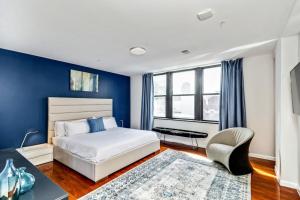 1 dormitorio con paredes azules, 1 cama y 1 silla en The place to stay! en Filadelfia