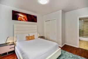 Un dormitorio con una cama blanca y una pintura en la pared en The place to stay! en Filadelfia