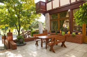 a wooden table and benches in front of a house at Gościniec Marzymięta in Czmoń