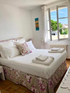 a bedroom with a bed with towels on it at Charming apartment in Port Grimaud in Grimaud