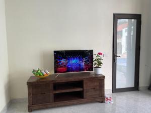 a flat screen tv sitting on top of a wooden entertainment center at An Bungalow - Mai Châu in Hòa Bình