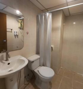 a bathroom with a toilet and a sink and a shower at Hotel Paraiso in Bangkok