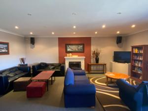 a living room with blue couches and a fireplace at Yuki Inn Jindabyne in Jindabyne