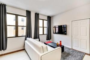 a white living room with a white couch and a table at Be My Guest Gorgeous 2BD next to Reading Terminal in Philadelphia