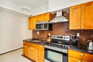 a kitchen with wooden cabinets and a stove top oven at Be My Guest Gorgeous 2BD next to Reading Terminal in Philadelphia