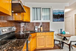 a kitchen with wooden cabinets and a table at 2BD Apartment next to Reading terminal and convention center in Philadelphia