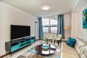 a living room with a couch and a flat screen tv at 2BD Apartment next to Reading terminal and convention center in Philadelphia