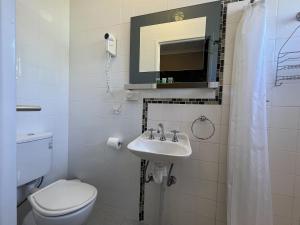 Baño blanco con aseo y lavamanos en Yuki Inn Jindabyne, en Jindabyne