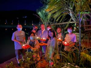 a group of people wearing masks and holding lights at Gumbie House in Fang