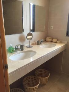 ein Badezimmer mit zwei Waschbecken und einem Spiegel und Körben in der Unterkunft Casa Dollita - Semi Penthouse - 90 square meters terrace -breathtaking seaview in Mijas
