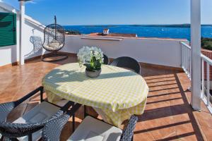 a table and chairs on a balcony with a table and flowers at Apartmani Marinka Viskovic in Hvar