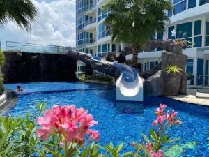 a slide in a pool at a resort at Grand Avenue Condo by Bormon in Pattaya Central