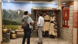 a group of people standing in front of a painting at Nomadic Inn in Dharamshala