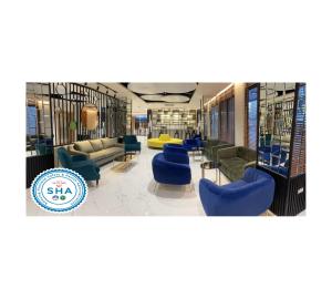 曼谷的住宿－The Neuf@Ratchada，一个带蓝色椅子和沙发的图书馆