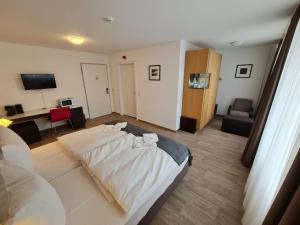 a bedroom with a bed and a living room at check-inn hotels - Offenbach in Offenbach