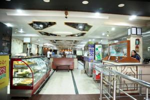 a fast food restaurant with a counter and people in it at Soundarya Hotel in Bengaluru