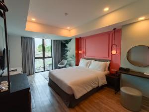 Habitación de hotel con cama y espejo en VIVA LA VIDA HOTEL, en Bangkok