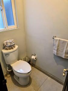 een badkamer met een wit toilet en een raam bij Clean&Equipped, 1-Floor 3-Bedroom Downtown House in Ensenada