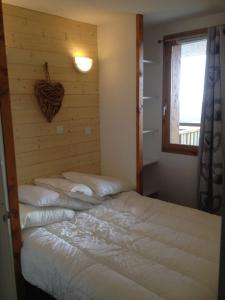 a bedroom with a large bed with a wooden wall at Lama-Gîte-des-Puys T3 Lamado vue époustouflante sud avec grande terrasse in Super Besse