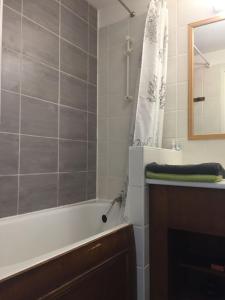 ein Badezimmer mit einer Badewanne, einem Waschbecken und einem Spiegel in der Unterkunft Lama-Gîte-des-Puys T3 Lamado vue époustouflante sud avec grande terrasse in Super Besse