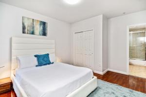 a white bedroom with a large bed and a window at Lovely 2bd Apt steps from the Convention Center in Philadelphia