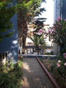 een tuin met bomen en bloemen naast een gebouw bij Fanari summer house 2 floors in Fanárion