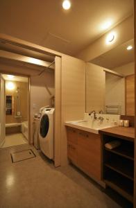 a bathroom with a sink and a washing machine at M House in Furano