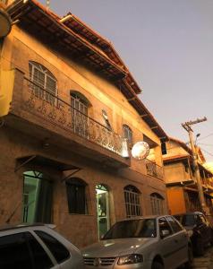 a car parked in front of a building with a balcony at Pousada King Stones - São Thomé das Letras - ÁREA CENTRAL in São Thomé das Letras