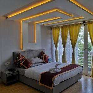 a bedroom with a large bed with yellow curtains at Zingo's Home Stay in Darjeeling