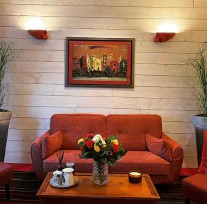 uma sala de estar com um sofá e uma mesa em Hôtel Carmin em Le Havre